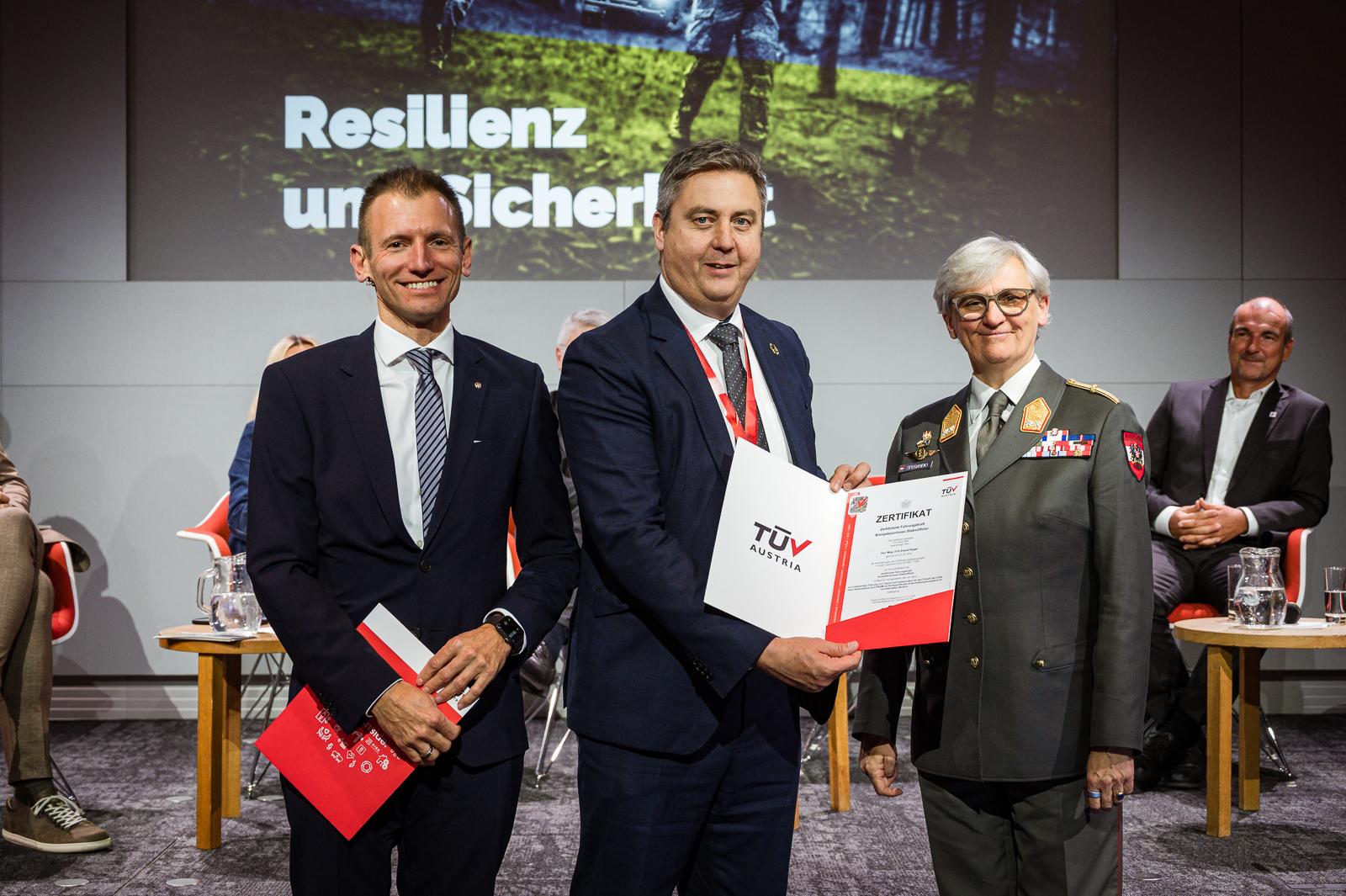 <br /> Drei Personen bei Zertifikatsübergabe.