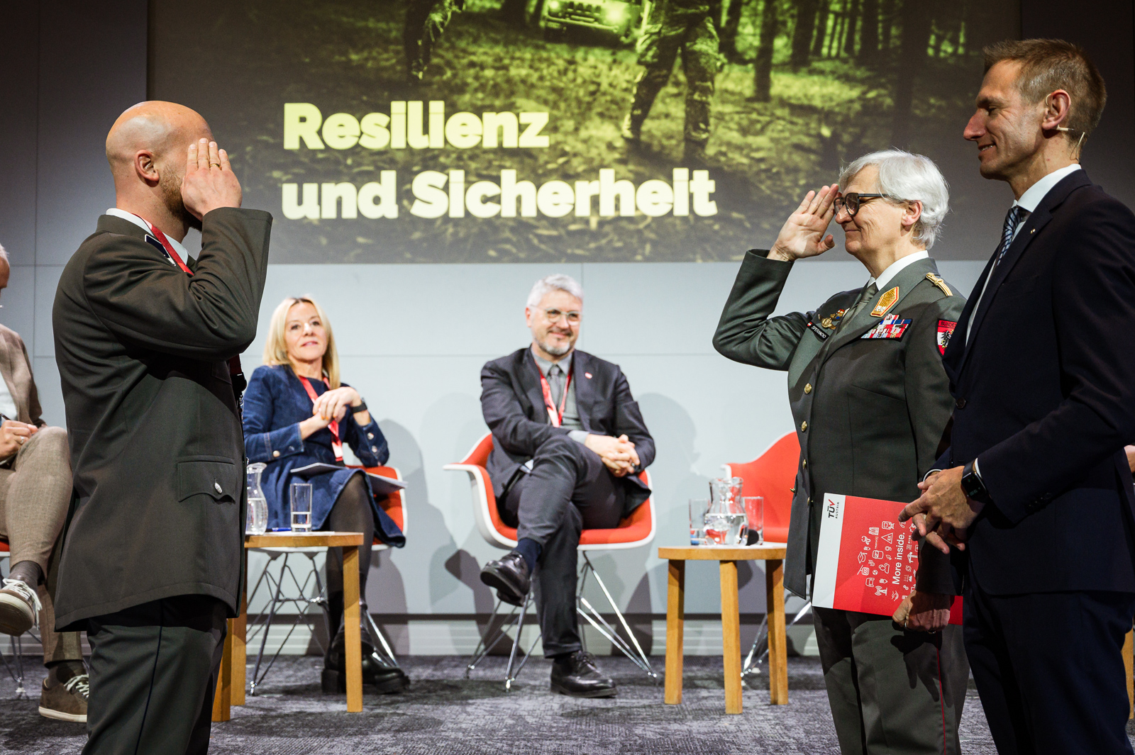 <br /> Zwei Personen salutieren auf der Bühne.